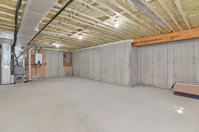 71 Pouts Ln Unit 0, Uxbridge, MA 01569 - unfinished basement featuring heating unit, tankless water heater, and electric panel