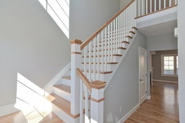 stairs with hardwood / wood-style flooring and a high ceiling