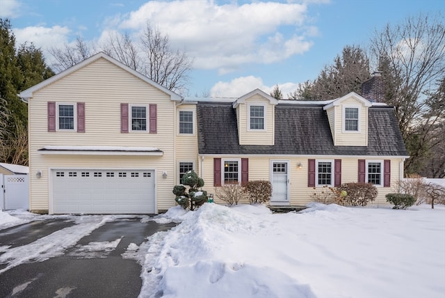 dutch colonial with aphalt driveway, a shingled roof, and an attached garage