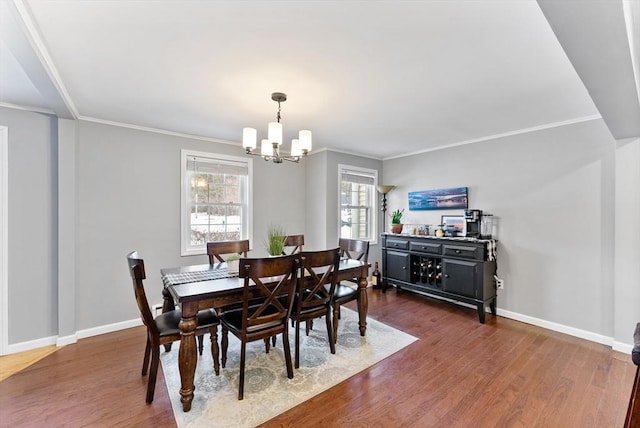 dining area with dark wood-style flooring, an inviting chandelier, and baseboards