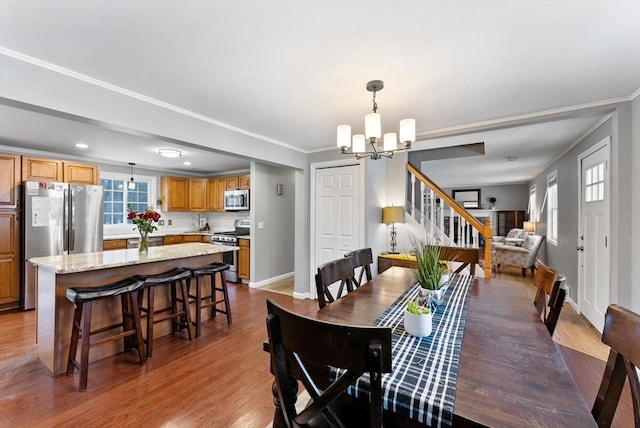 dining space featuring crown molding, dark wood-style flooring, a notable chandelier, and baseboards