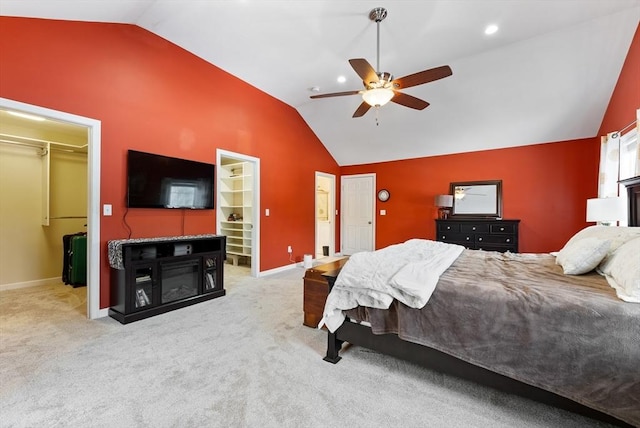 carpeted bedroom with lofted ceiling, a walk in closet, and a closet