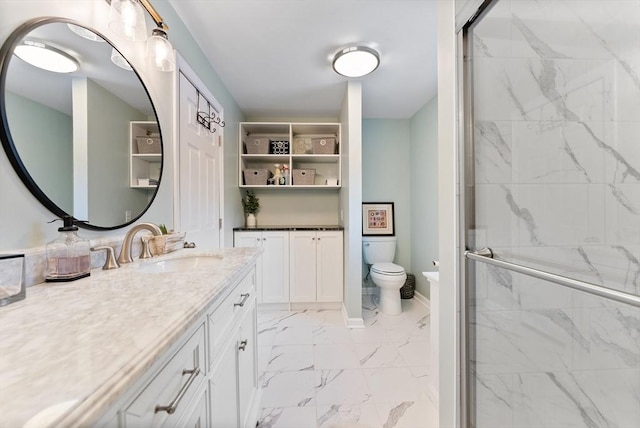 bathroom with marble finish floor, a marble finish shower, toilet, vanity, and baseboards