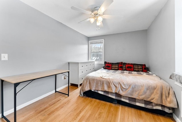 bedroom with light wood-style flooring, baseboards, and a ceiling fan