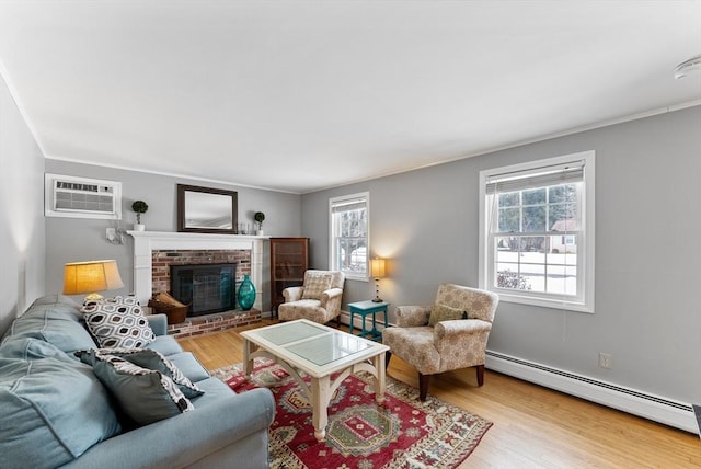 living room featuring a baseboard radiator, an AC wall unit, a healthy amount of sunlight, and wood finished floors