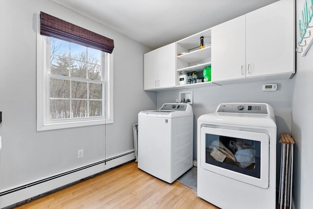 laundry room with cabinet space, a baseboard radiator, washer and clothes dryer, and light wood finished floors