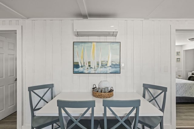 dining room featuring a wall mounted air conditioner, wood finished floors, a decorative wall, attic access, and breakfast area
