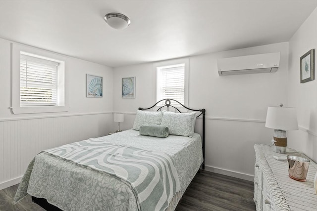 bedroom featuring a wall mounted AC, dark wood-type flooring, multiple windows, and a wainscoted wall