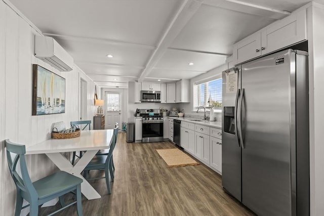 kitchen with appliances with stainless steel finishes, a wall mounted air conditioner, dark wood-style floors, light countertops, and recessed lighting