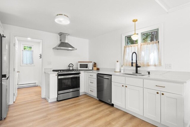 4 Agawam Ave, Ipswich, MA 01938 - kitchen with wall chimney exhaust hood, stainless steel appliances, a sink, a baseboard heating unit, and white cabinetry