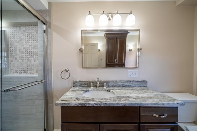 bathroom with toilet, a stall shower, and vanity