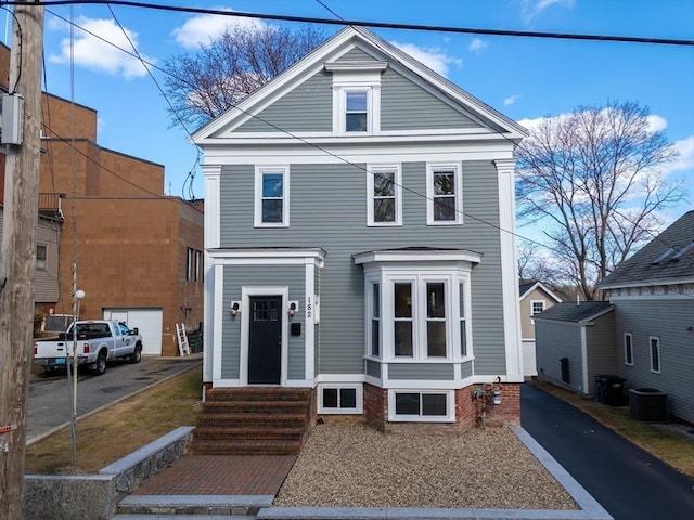 greek revival house featuring entry steps, aphalt driveway, and central air condition unit