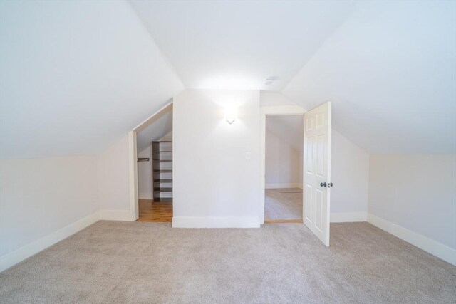 bonus room featuring carpet, lofted ceiling, and baseboards