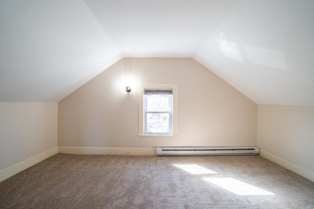 additional living space with a baseboard heating unit, carpet floors, vaulted ceiling, and baseboards