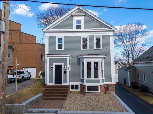 greek revival house featuring entry steps, aphalt driveway, and cooling unit