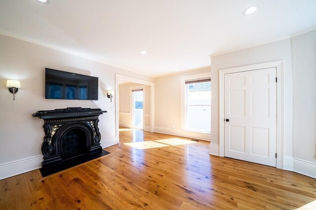 unfurnished living room with hardwood / wood-style flooring, crown molding, and recessed lighting