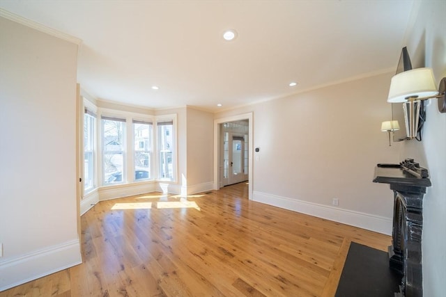 living area featuring baseboards, recessed lighting, light wood-type flooring, and crown molding