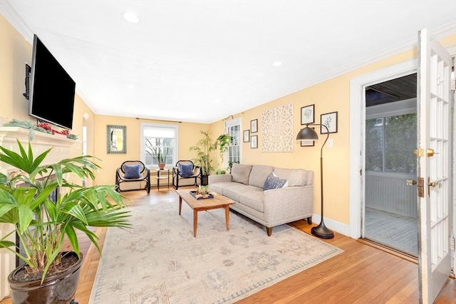 living room with crown molding, hardwood / wood-style floors, and french doors