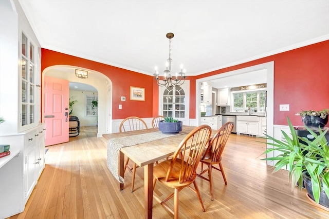 dining area featuring crown molding, a notable chandelier, and light hardwood / wood-style floors