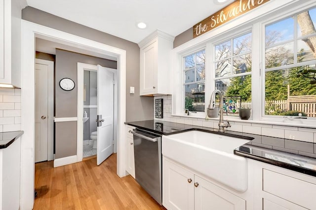 kitchen featuring white cabinetry, dishwasher, sink, and tasteful backsplash