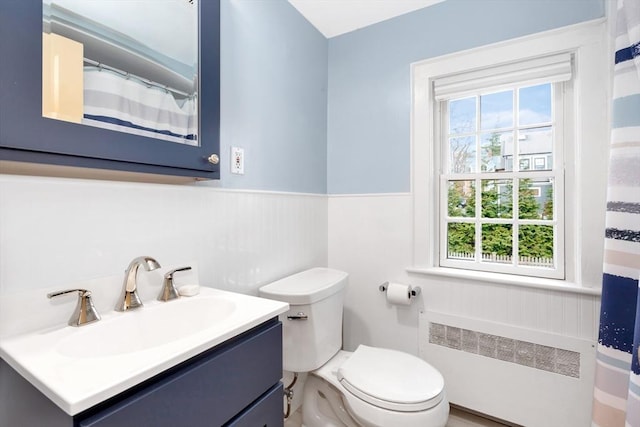 bathroom featuring vanity, radiator, a wealth of natural light, and toilet