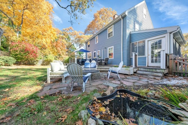 rear view of property with outdoor lounge area, a patio, and a lawn