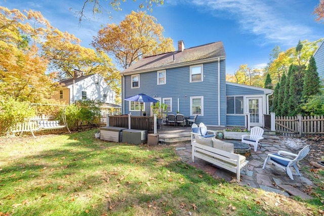 rear view of house featuring a wooden deck, outdoor lounge area, and a yard