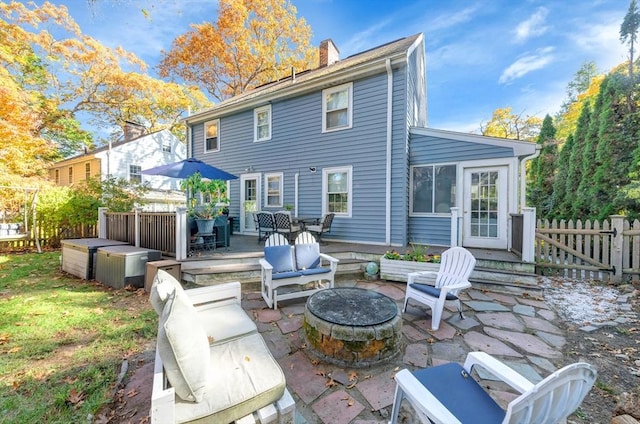 rear view of house featuring a patio and an outdoor living space with a fire pit