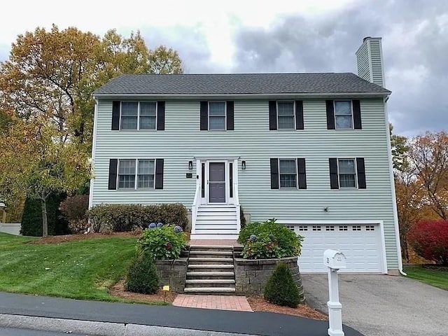 colonial-style house with a front yard and a garage