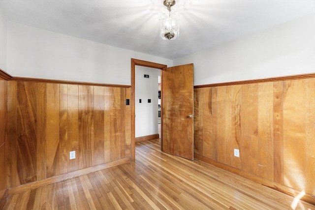 spare room with wooden walls and hardwood / wood-style floors