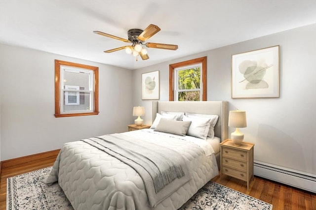 bedroom featuring baseboards, a baseboard radiator, a ceiling fan, and wood finished floors
