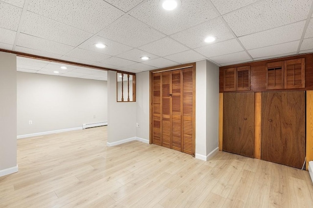 finished basement featuring baseboards, a baseboard heating unit, recessed lighting, and light wood-style flooring