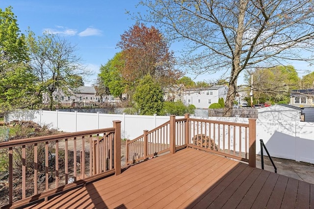 wooden terrace featuring a fenced backyard and a residential view