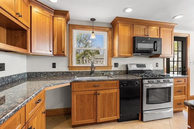 kitchen featuring a sink, brown cabinetry, black appliances, and dark stone countertops