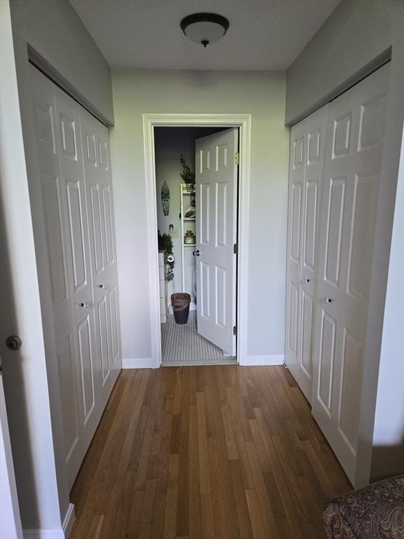 corridor featuring wood finished floors and baseboards