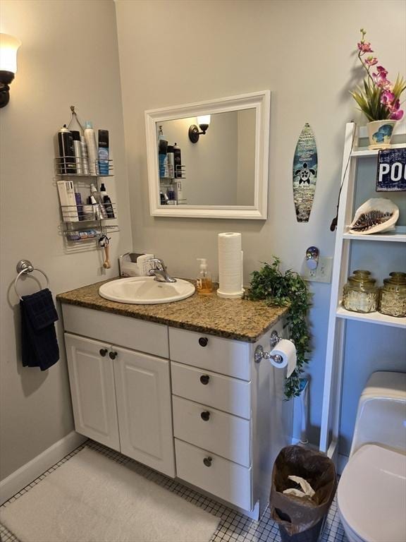 bathroom with vanity, baseboards, and tile patterned flooring