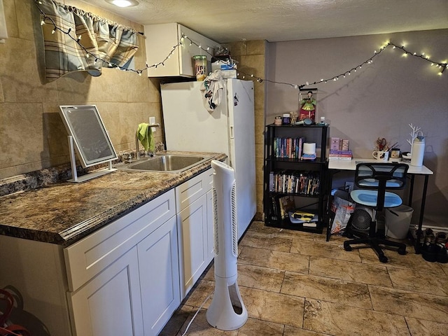 16 Boyd Ave, East Providence, RI 02914 - kitchen with white cabinets, a sink, freestanding refrigerator, dark countertops, and stone finish floors