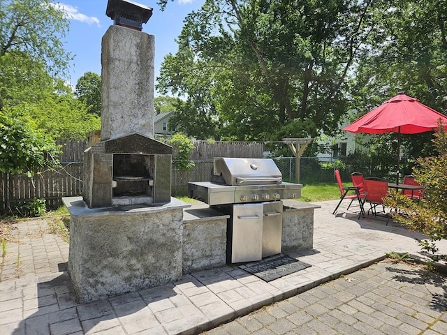 16 Boyd Ave, East Providence, RI 02914 - fenced backyard featuring an outdoor stone fireplace, a patio area, and outdoor dining space