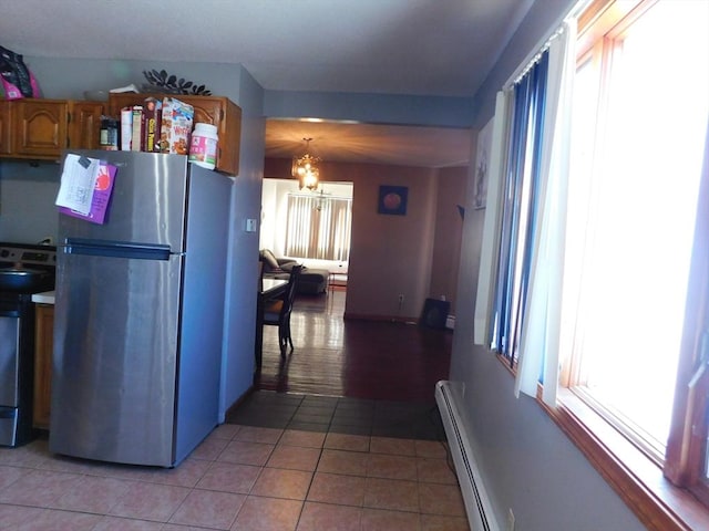 kitchen featuring range with electric stovetop, stainless steel fridge, plenty of natural light, and light tile patterned floors