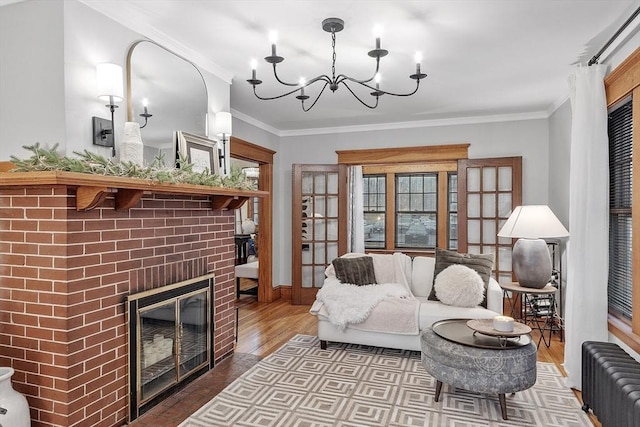 living room featuring hardwood / wood-style floors, crown molding, radiator heating unit, and a fireplace