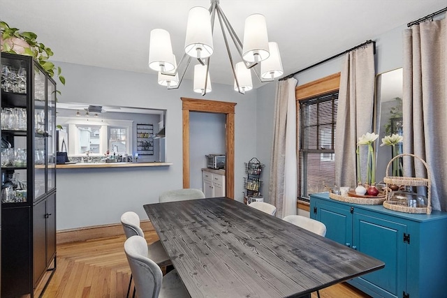 dining room with light parquet flooring and a notable chandelier