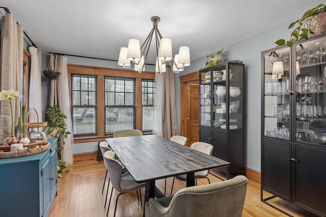 dining space featuring light hardwood / wood-style flooring and a chandelier