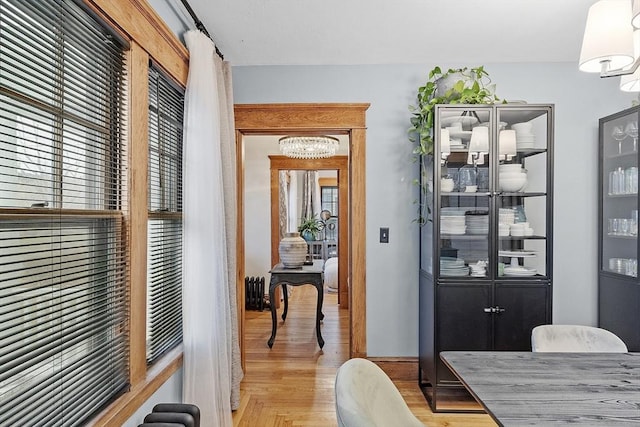 corridor featuring radiator, plenty of natural light, and light hardwood / wood-style flooring