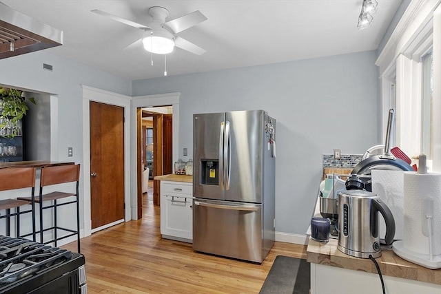 kitchen with white cabinetry, ceiling fan, light hardwood / wood-style flooring, stainless steel refrigerator with ice dispenser, and stove