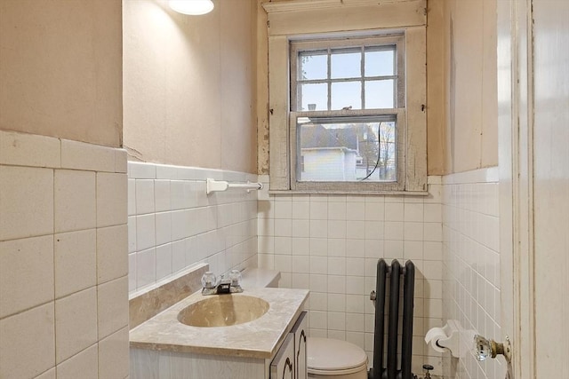 bathroom featuring vanity, toilet, and tile walls