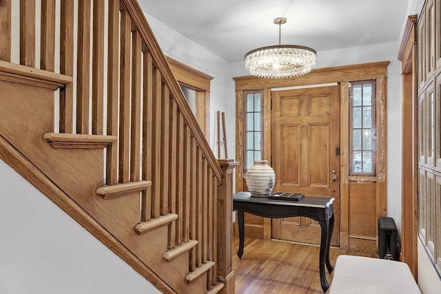 foyer entrance featuring hardwood / wood-style flooring and a notable chandelier