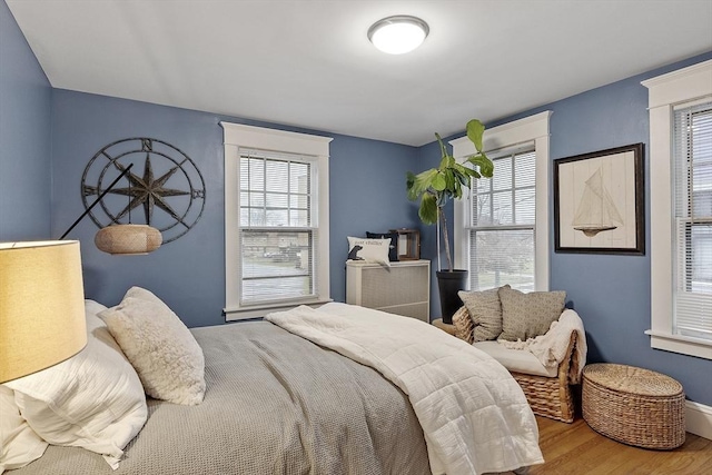 bedroom featuring multiple windows and hardwood / wood-style flooring