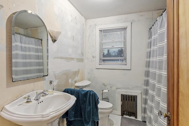 bathroom with toilet, sink, and radiator