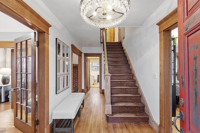 foyer entrance with an inviting chandelier and light wood-type flooring