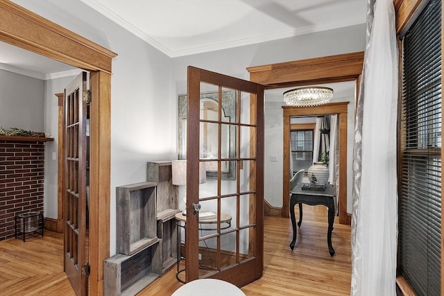 hall featuring a chandelier, french doors, light wood-type flooring, and ornamental molding